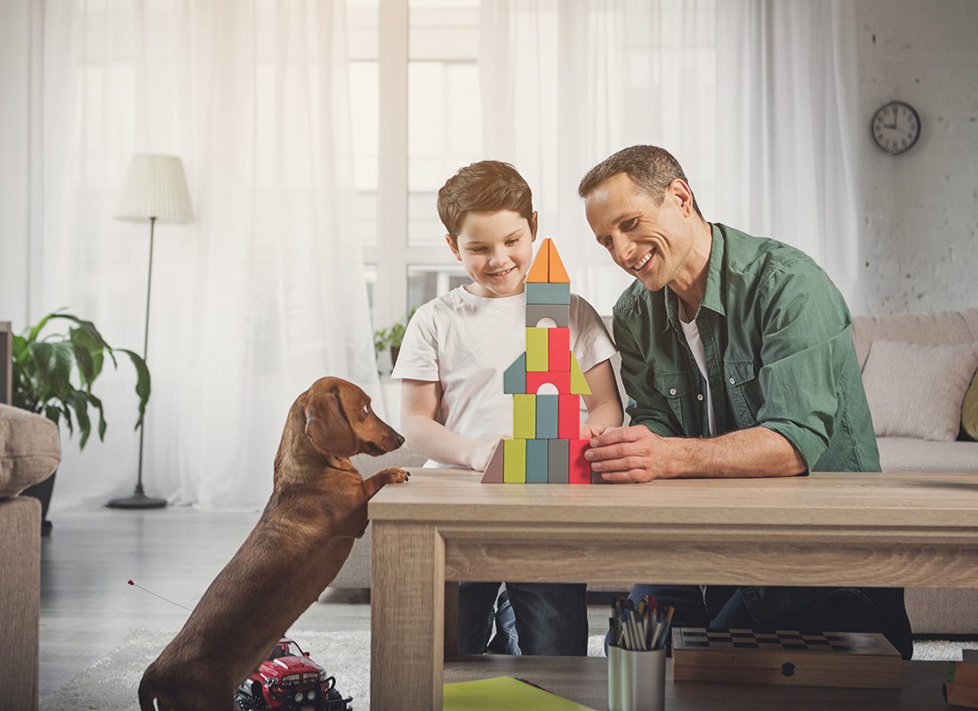 Personal Insurance - Happy Father and Son Play With Building blocks While Their Dog Looks on